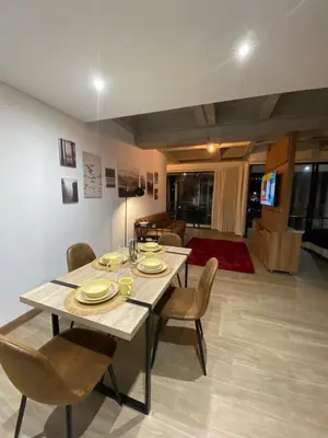 a dining table and chairs in a living room at Art, design and urban life in Medellín loft in Medellín