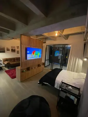 a bedroom with a bed and a flat screen tv at Art, design and urban life in Medellín loft in Medellín