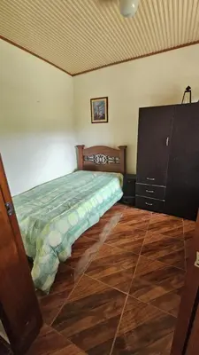 a bedroom with a bed and a dresser at Casa campestre tranquila cerca de termales in Santa Rosa de Cabal