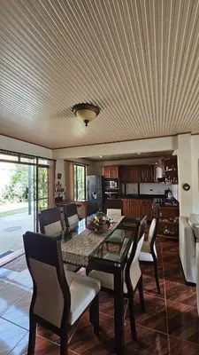 a living room with a dining room table and chairs at Casa campestre tranquila cerca de termales in Santa Rosa de Cabal