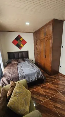 a bedroom with a bed and a large wooden cabinet at Casa campestre tranquila cerca de termales in Santa Rosa de Cabal