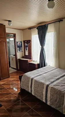 a bedroom with a bed and a large window at Casa campestre tranquila cerca de termales in Santa Rosa de Cabal