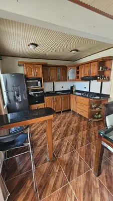 a kitchen with wooden cabinets and a wooden floor at Casa campestre tranquila cerca de termales in Santa Rosa de Cabal
