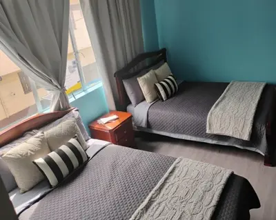 a bedroom with two beds and a window at Hotel Bolivar in Manizales