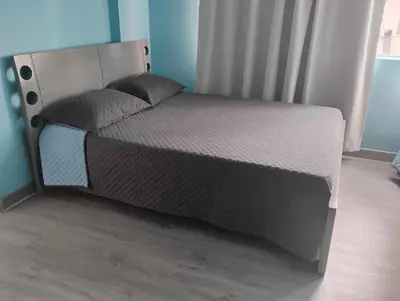 a bed in a room with a bed frame at Hotel Bolivar in Manizales