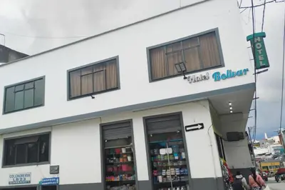 a white building with windows on a street at Hotel Bolivar in Manizales