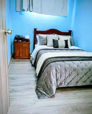 a blue bedroom with a bed and a night stand at Hotel Bolivar in Manizales