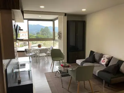a living room with a couch and a table with chairs at Beautiful Loft close to airport,pool gym & parking in Rionegro