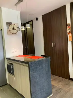 a kitchen with a counter and a clock on the wall at Beautiful Loft close to airport,pool gym & parking in Rionegro
