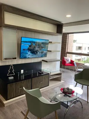 a living room with a flat screen tv on a wall at Beautiful Loft close to airport,pool gym & parking in Rionegro