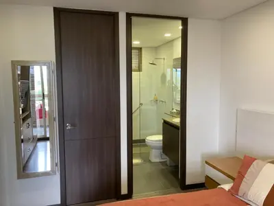 a bathroom with a toilet and a glass shower at Beautiful Loft close to airport,pool gym & parking in Rionegro