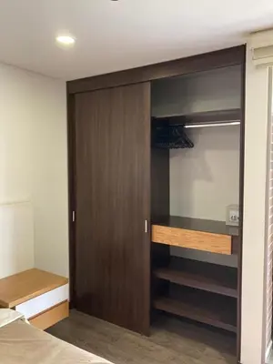 a bedroom with a closet with a wooden door at Beautiful Loft close to airport,pool gym & parking in Rionegro