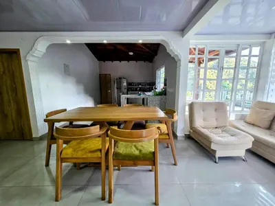 a dining room with a wooden table and chairs at Finca La Rosa in Ebéjico