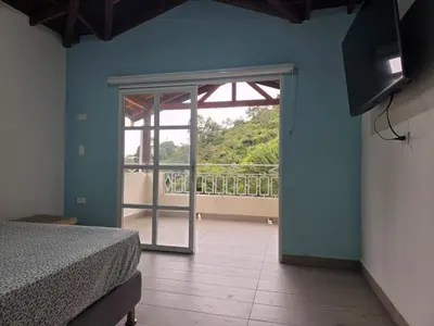 a bedroom with a bed and a sliding glass door at Finca La Rosa in Ebéjico