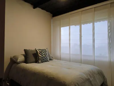 a bedroom with a bed and a large window at Cabaña privada Reserva Rio Blanco Manizales in Manizales