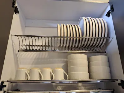 a refrigerator filled with plates and mugs on a shelf at Cabaña privada Reserva Rio Blanco Manizales in Manizales