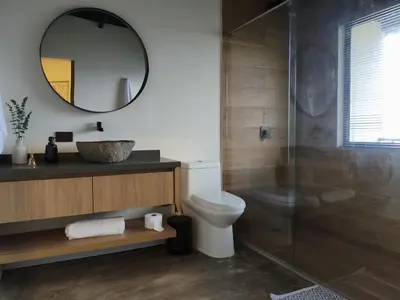 a bathroom with a toilet and a sink and a mirror at Cabaña privada Reserva Rio Blanco Manizales in Manizales