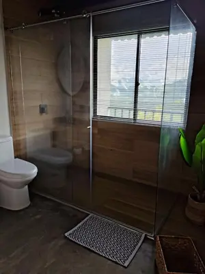 a bathroom with a shower with a toilet and a window at Cabaña privada Reserva Rio Blanco Manizales in Manizales