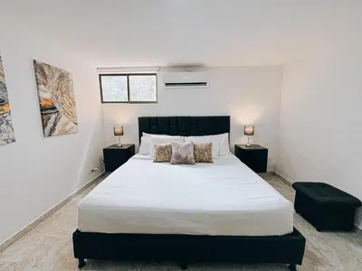a bedroom with a large white bed with two night stands at casa patio bonito in Medellín
