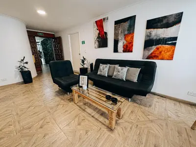 a living room with a black couch and a coffee table at casa patio bonito in Medellín