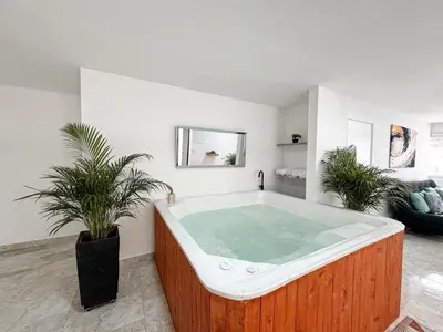 a jacuzzi tub in a room with plants at casa patio bonito in Medellín