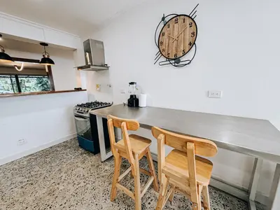 a kitchen with a counter and two wooden chairs at casa patio bonito in Medellín