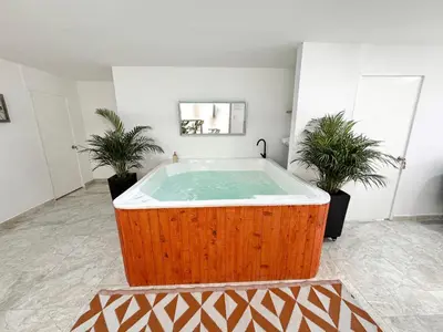 a hot tub in a room with two potted plants at casa patio bonito in Medellín