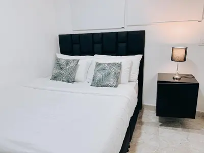 a bedroom with a large bed with a black headboard at casa patio bonito in Medellín