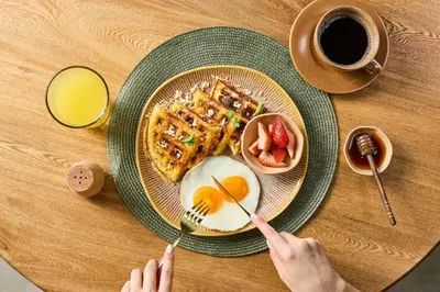 a person eating a breakfast plate of eggs and waffles at Holistic EcoHotel in Santa Fe de Antioquia