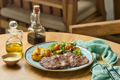 a plate of steak and vegetables on a table at Holistic EcoHotel in Santa Fe de Antioquia