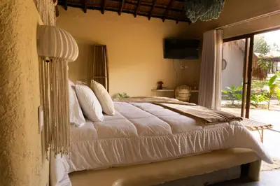 a bedroom with a large bed with white sheets at Holistic EcoHotel in Santa Fe de Antioquia