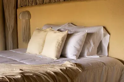 a white bed with four pillows on it at Holistic EcoHotel in Santa Fe de Antioquia