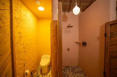a bathroom with a toilet and a yellow wall at Holistic EcoHotel in Santa Fe de Antioquia