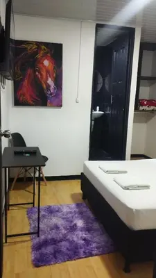 a bedroom with a painting of a horse on the wall at Hotel Palacio in Manizales