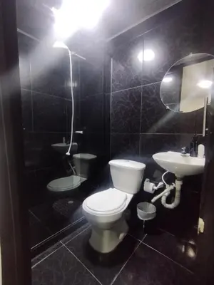a black tiled bathroom with a toilet and a sink at Hotel Palacio in Manizales