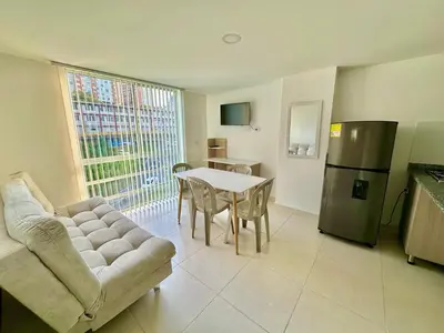a living room with a couch and a table and a refrigerator at Central Urbano 3 habitaciones hasta 8 personas CC Fundadores U Autonoma in Manizales