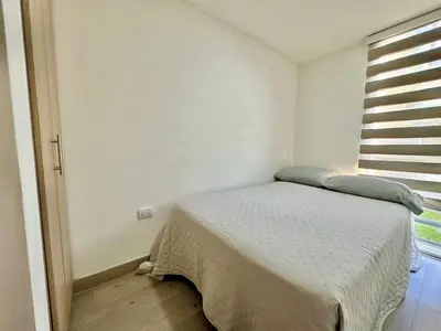 a small bedroom with a bed and a window at Central Urbano 3 habitaciones hasta 8 personas CC Fundadores U Autonoma in Manizales