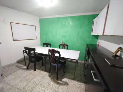 a kitchen with a table and chairs and a green wall at Kumho in Medellín