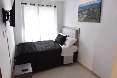 a small bedroom with a bed and a window at Laureles Sweet Home in Medellín