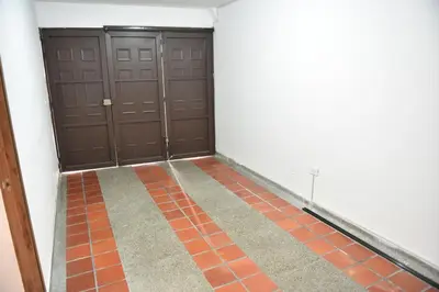 a hallway with two brown doors and a tile floor at Laureles Sweet Home in Medellín
