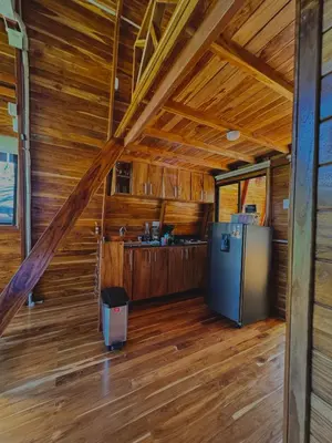 a kitchen in a log cabin with a refrigerator at Refugio la Arboleda in San Rafael