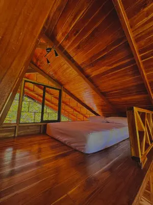 a bedroom with a bed in a wooden attic at Refugio la Arboleda in San Rafael