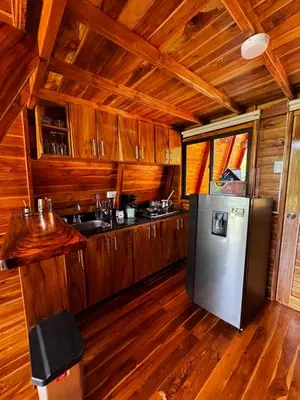 a kitchen with wooden cabinets and a refrigerator at Refugio la Arboleda in San Rafael