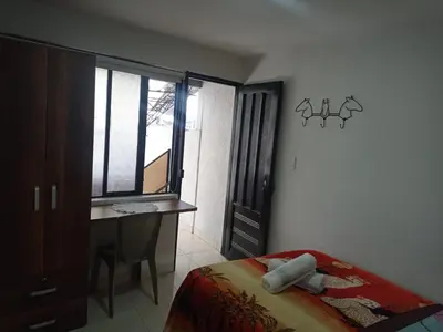 a bedroom with a bed and a desk and a window at La Recua Manizales in Manizales