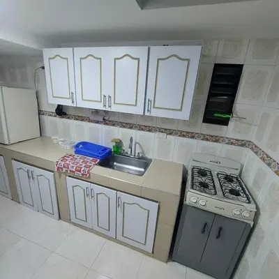 a kitchen with white cabinets and a sink and a stove at La Recua Manizales in Manizales