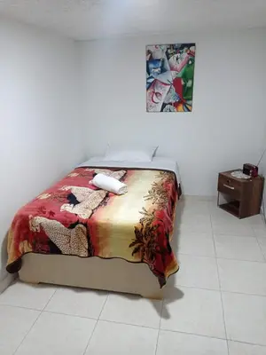 a bed sitting in a room with a table at La Recua Manizales in Manizales