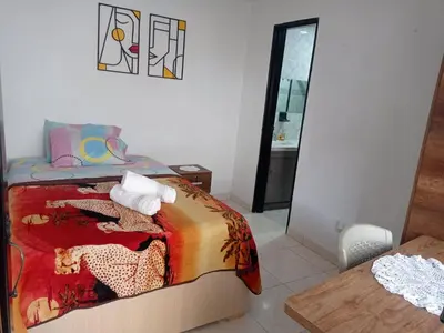 a bedroom with a bed and a table and a mirror at La Recua Manizales in Manizales