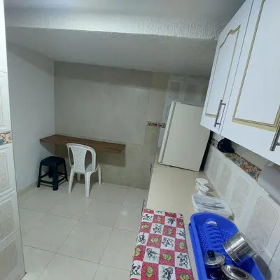 a small kitchen with a table and a refrigerator at La Recua Manizales in Manizales