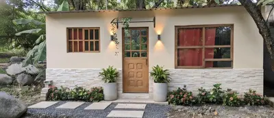 a small house with a door and two potted plants at Casa Hotel Vacacional Honda in Honda