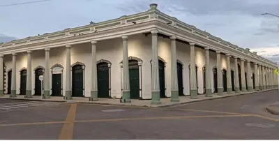 a large white building with columns on a street at Casa Hotel Vacacional Honda in Honda